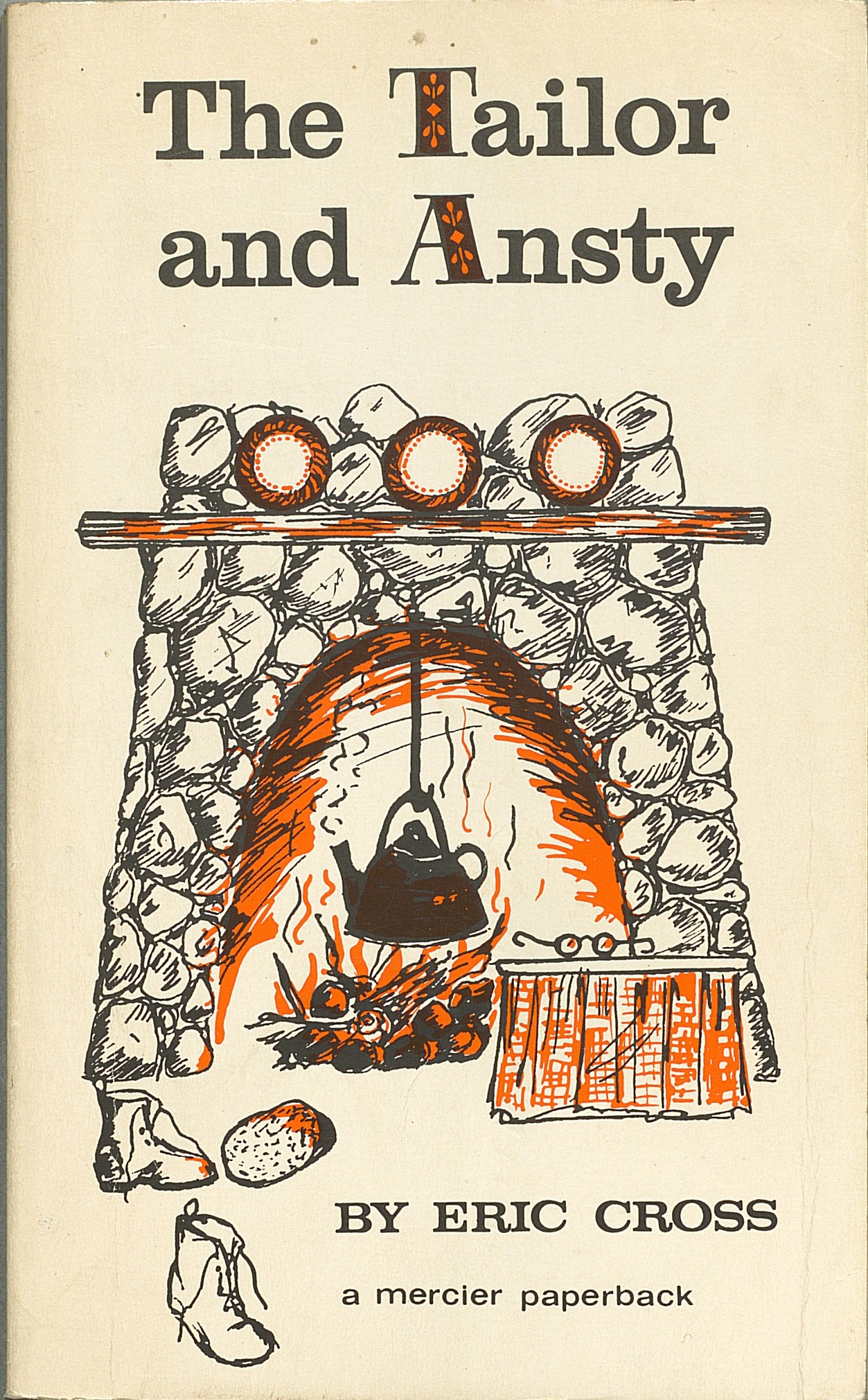 Cover to the 1970 paperback edition. There is a kettle hung over the fire in the hearth. In front of the fireplace is a pair of glasses on a small table on the right and on the left there is a pair of boots.