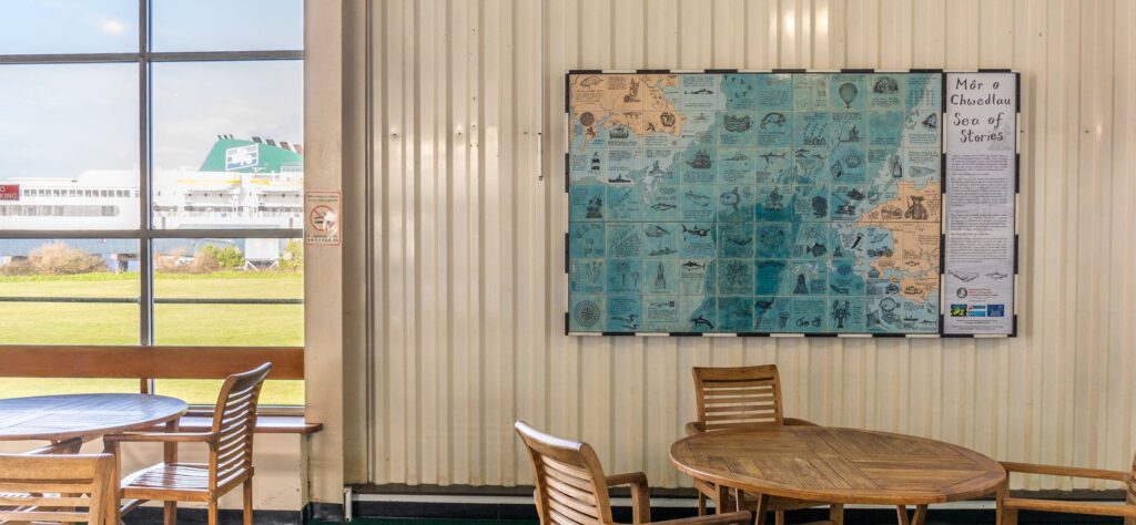 Mural in situ in the Pembroke Dock ferry terminal with ferry visible through window behind the building