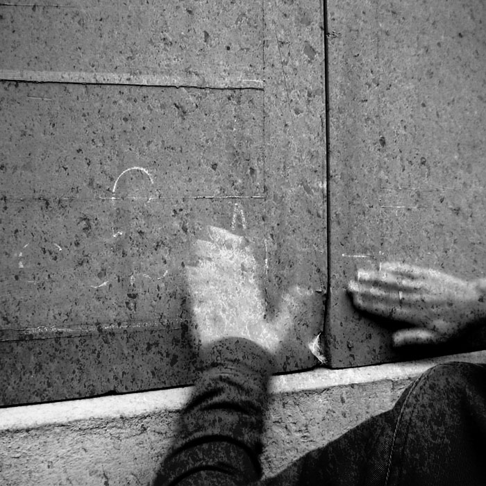 Photograph of two hands wiping chalk writing off a wall representing the opposite of preservation