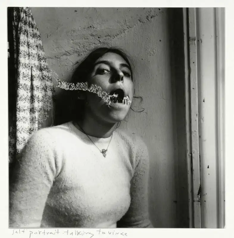 Black and white photograph by Francesca Woodman of women with plastic coil in mouth. Self-portrait.