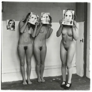 Black and white photograph by Francesca Woodman of three nude female standing in an empty room, each holding a mask with face of Francesca Woodman in front of their faces.