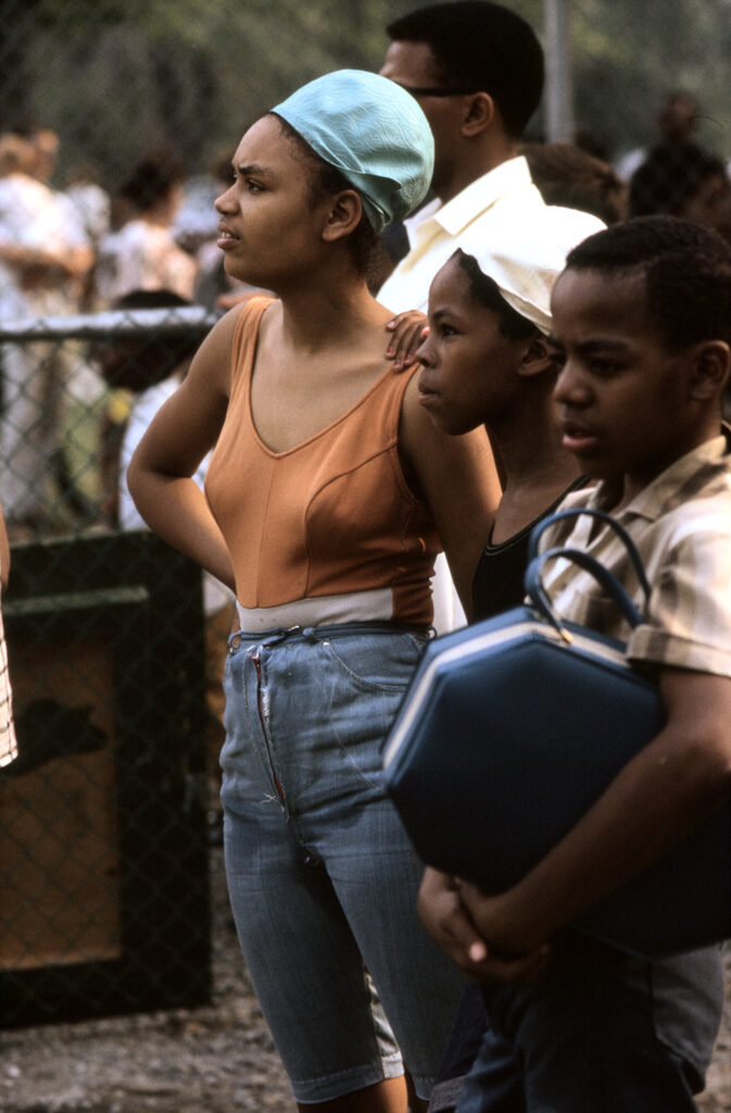 Three African-American children standing in a row. In Detroit, Michigan. Colour photograph by Alen MacWeeney. Black History Month.