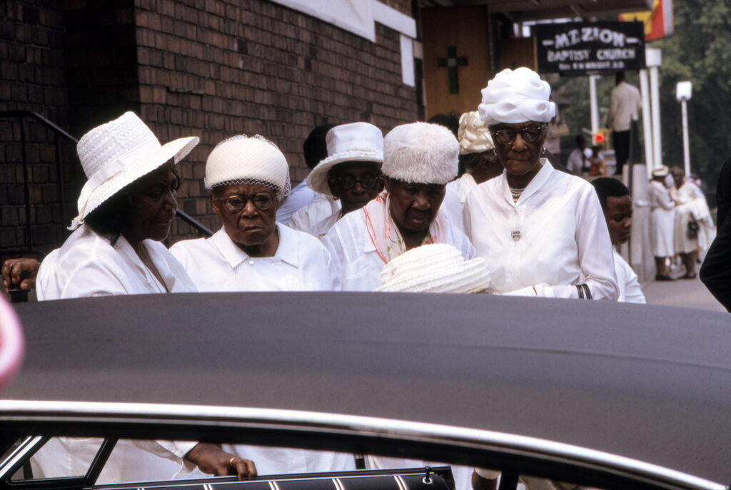 Five African-American women dressed in white. Before or after church service. Detroit, Michigan. Colour photo take by Alen MacWeeney. Black History Month.