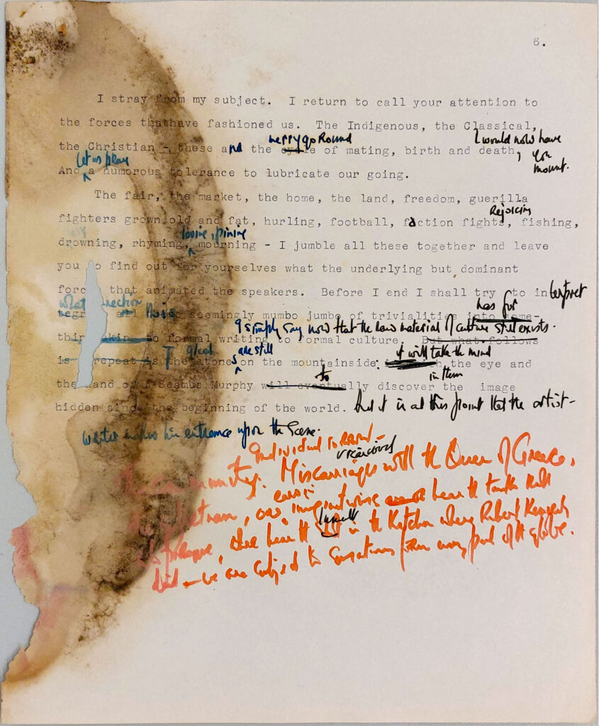 Draft typescript paper sheet with manuscript annotations in red, blue and red ink. water damaged and mould damage