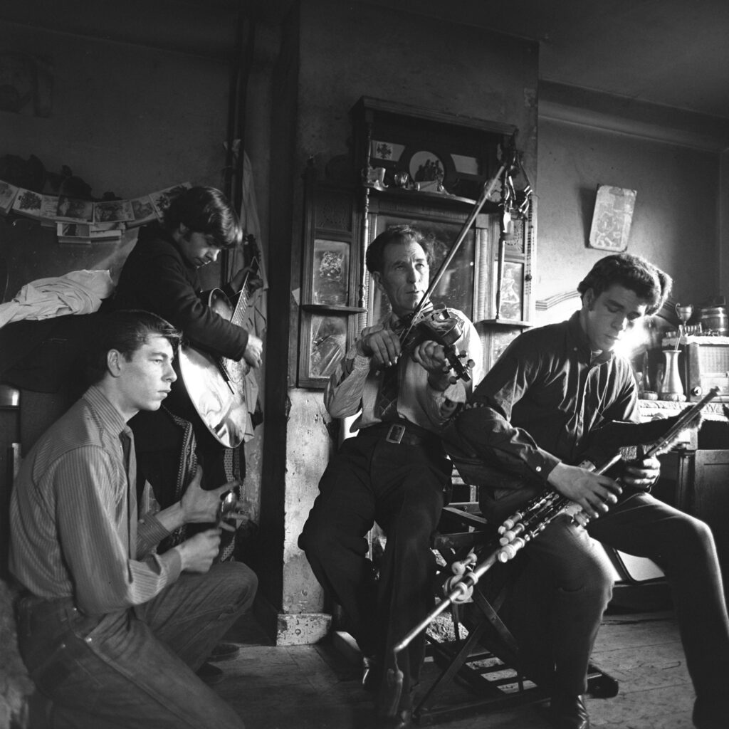 Black and white photo of four traditional Irish musicians take by Alen MacWeeney.