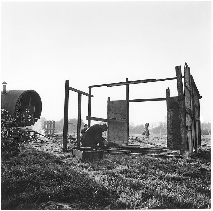 Black and white photo by Alen MacWeeney of man building a hut.