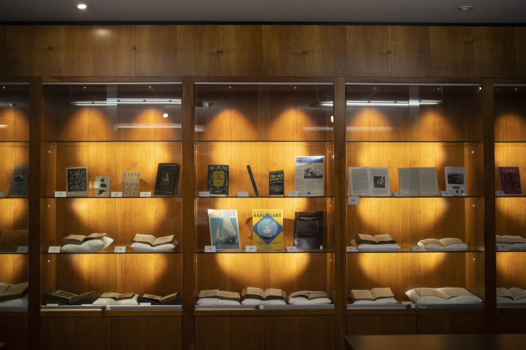 Three illuminated cabinets showing examples of items for Special Collections' exhibition focusing on Sustainable Development Goal 14: Life Below Water.